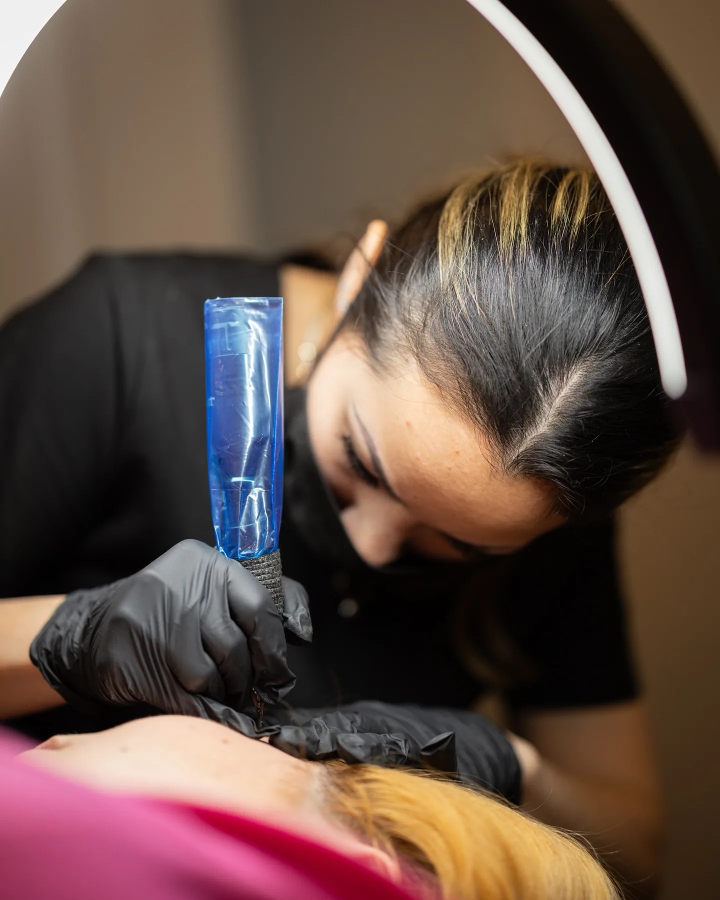 Sheyla at work, close in on a client's brow