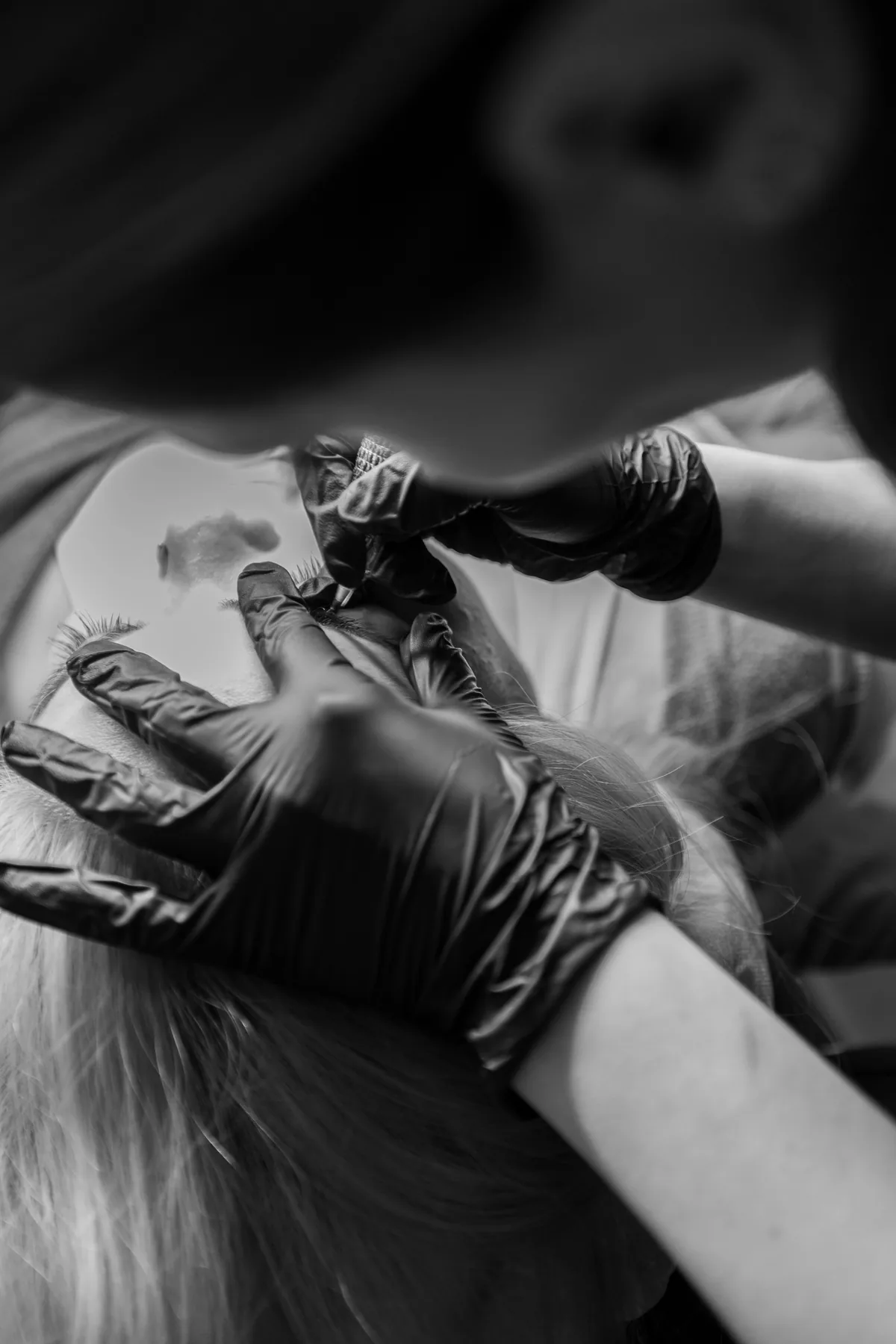 Gloved hands mid-procedure, black and white